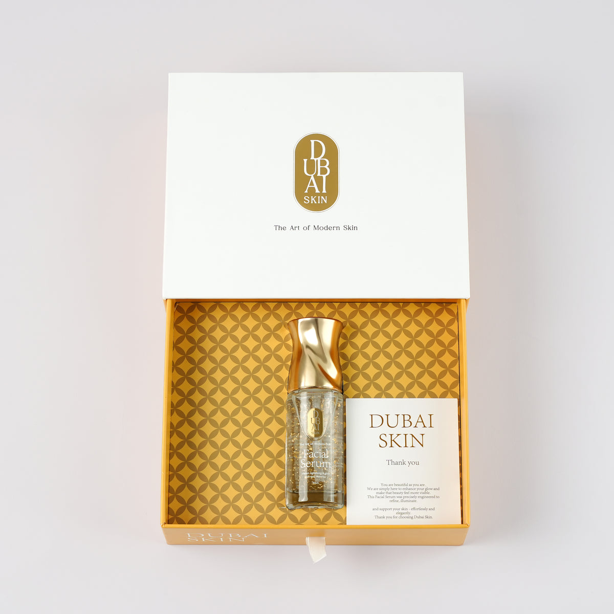 Overhead view of Dubai Skin facial serum and thank-you card in the open box